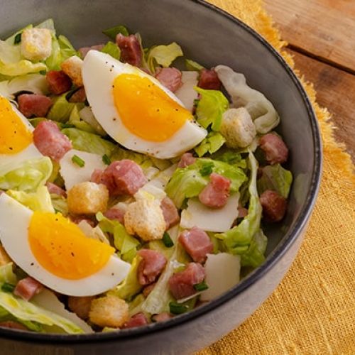 Caesar Salad con crostini, uovo e cubetti di pancetta