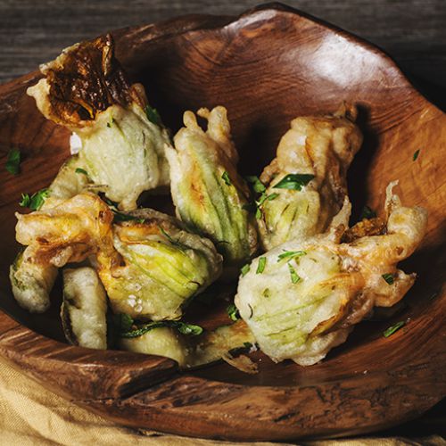 Fried zucchini flowers filled with smoked scamorza cheese and cooked ham
