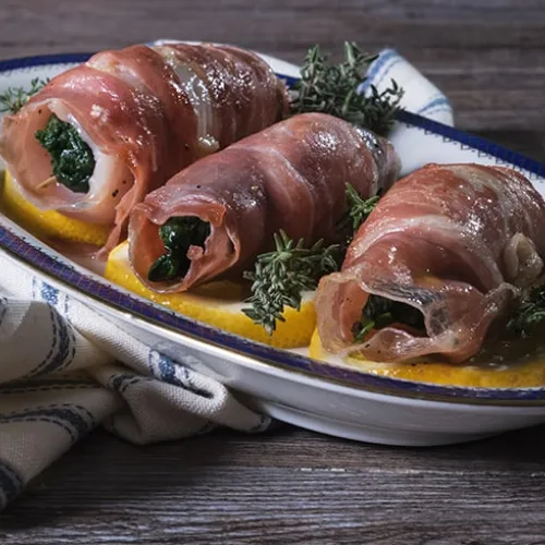 Involtini di orata al profumo di limone con prosciutto crudo e spinaci saltati