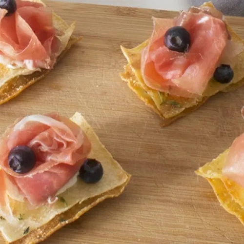 Millefoglie di pane carasau con prosciutto crudo, caprino e mirtilli