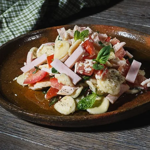 Pasta estiva con pomodori, ricotta salata, petali di petto di pollo ed erbe