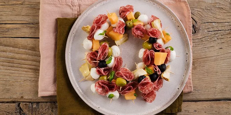 Cerchio di spiedini con salame, olive, carciofi, mozzarelline e melone